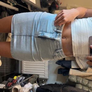 Ljusblå jeanskjol från Gina - Säljer en ljusblå jeanskjol med klassisk femficksmodell och dragkedja framtill. Kjolen har en rak passform och är perfekt för dig som gillar en enkel men snygg stil.