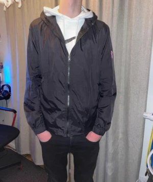 Svart Windbreaker - Risky Universe Windbreaker. Storlek S. Inga defekter, enda är att jag har tagit ut snörena och hittar ej dem nu.