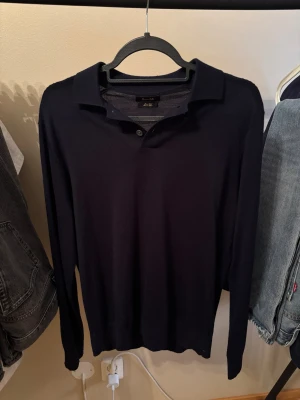 Massimo Dutti kofta  - Snygg mörkblå kofta från Massimo Dutti i mjuk merinoull. Klassisk krage med två diskreta knappar framtill och långärmad passform. Perfekt för dig som gillar stilrena och bekväma plagg med lite lyxig känsla.