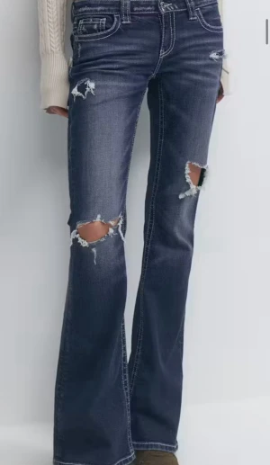 Blå lågmidjade bootcut jeans med slitningar - Snygga blåa bootcut jeans med en låg midja och slitna detaljer på knäna och låren. Sömmen på ena benet har gått upp lite men var så när jag köpte de, annars i ett jättebra skick💞