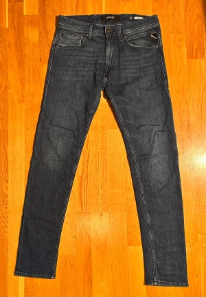 Replay jeans - Snygga mörkblå jeans från Replay med klassisk femficksdesign och diskreta kontrastsömmar. Modellen har slim fit-passning och raka ben, med knapp och dragkedja i midjan. Perfekt för dig som gillar stilrena och moderna jeans.