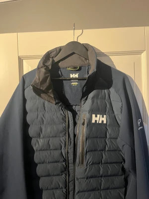 Helly Hansen hybrid  - Snygg helly Hansen hybrid i storlek L. Inga större tecken på användning endast lite vattenfläckar skulle jag tro. Har aldrig använt den själv. Kan gå ner i pris vid en snabb affär. För fler frågor och funderingar är det bara att höra av sig MVH