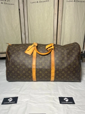 Louis Vuitton Keepall 55 - Louis Vuitton Keepall 55 - Vesken er i fin tilstand utvendig og innvendig, men noe slitasje på innsiden (se vedlagt bilde). Glidelås fungerer som den skal og vesken har ingen defekter - Datecode:SD834 - Pris: 4999kr - Vesken har autentisk bevis i samarbeid med LegitApp