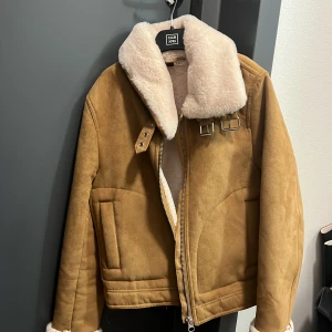 Beige teddyjacka från Divided - Säljer en beige teddyjacka från Divided med fluffig vit krage och muddar