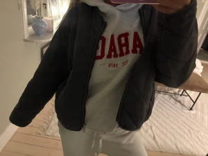 Mörkgrå quiltad pufferjacka - Säljer en mörkgrå pufferjacka med quiltad design och dragkedja framtill. Jackan har en clean look och är perfekt för dig som gillar en chill och enkel stil. Den är långärmad och har en normal passform som funkar till de flesta outfits.