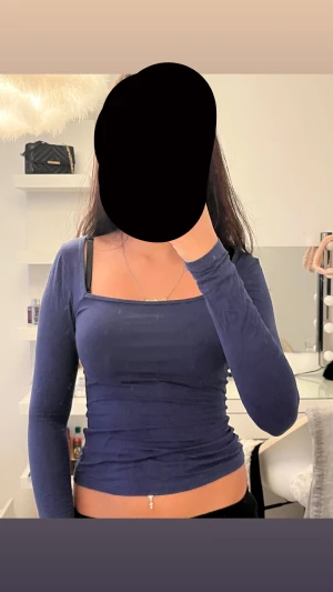 Mörkblå långärmad topp med fyrkantig hals - Säljer en mörkblå långärmad topp med snygg fyrkantig halsringning. Modellen är tight och croppad, Materialet känns mjukt och stretchigt mot kroppen.