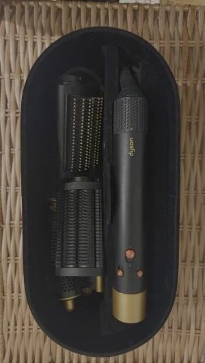 Dyson Airwrap Complete - Dyson Airwrap Complete i svart/guld med flera stylingtillbehör. Inkluderar originalförvaringsbox och olika borstar och cylindrar för lockar, volym och utjämning. Produkten är välvårdad med minimalt slitage, perfekt för mångsidig hårstyling hemma.