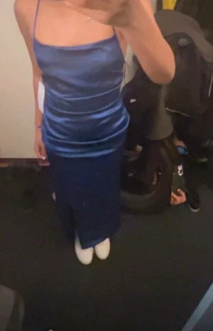 Bal klänning 💗 - Säljer en snygg BAL KLÄNNING i satin med smala axelband och öppen rygg med snörning. Klänningen har en figurnära passform och slät yta som ger en lyxig känsla. Perfekt för dig som vill sticka ut med en elegant och modern look.