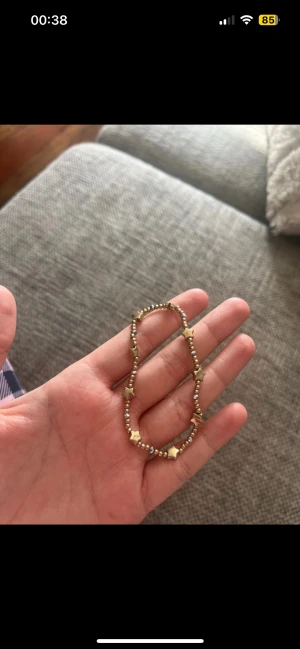 Guldfärgat armband med stjärnor - Superfint armband med små guldfärgade pärlor och stjärnformade detaljer. Armbandet är elastiskt och har en snygg mix av guld som ger en cool vibe. Perfekt accessoar för att lyfta din stil med lite extra bling.