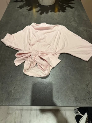 Ljusrosa bolerotopp från Gina Tricot - Supersöt ljusrosa bolerotopp från Gina Tricot med knyt framtill. Toppen har trekvartsärmar och är gjord i mjuk bomull, perfekt att slänga över ett linne eller klänning för en chill look.💞💞
