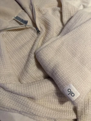 Vitt sett från Alo - Säljer ett helt Kashmir sett från ALO köpt i LA. Tröjan har ett snyggt, grovt stickat mönster och lång ärm med Alo-logga på mudden.  Byxorna är något korta då jag tvättat dom i tvättmaskin. 