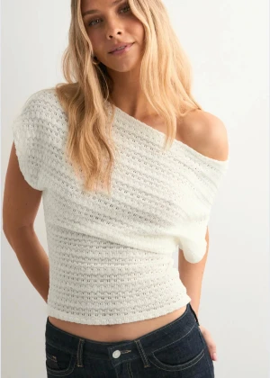 Vit stickad offshoulder topp - Säljer en vit stickad topp med offshoulder-design och korta ärmar. Endast använd någon enstaka gång!