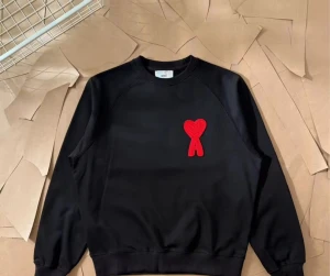 Svart sweatshirt från Ami Paris med rött hjärta - Svart sweatshirt från Ami Paris med ikonisk röd hjärtlogga på bröstet. Tröjan har rund hals, ribbade muddar och är tillverkad i mjuk bomull. Perfekt för dig som gillar stilrena plagg med en twist. Storlek S, originaltags medföljer. Tröjan är aldrig använd orginal påse med följer, priset går att diskutera☺️