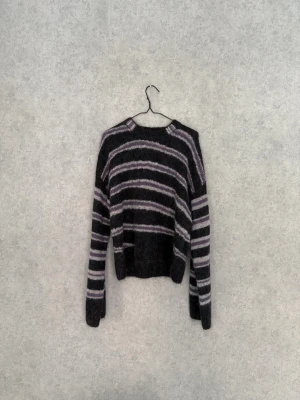 Mohair tröja Acne Studios - Mjuk och fluffig stickad tröja från Acne Studios i svart med lila och ljusgrå ränder. Rund hals och långa ärmar. Materialet är ullblandning som ger en skön känsla och snygg struktur. Size XS men sitter som S. Skriv vid fler frågor eller bilder 🤝🏼
