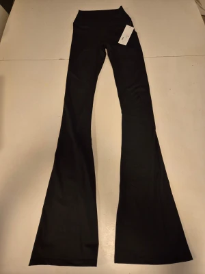 Mklifestyle Shape Flare Pants - Utsvängda svarta tights från Mklifestyle i supermjukt och behagligt tyg. Väldigt stretchiga och följsamma med diskret scrunch i rumpan, som ger en garanterat snygg 🍑 78% polyester, 22% spandex. Storlek XS Tall, se mått på sista bilden, något små i storlek. Nya med prislapp.