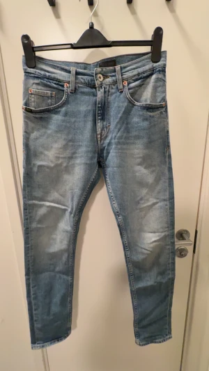 Tiger of Sweden ljusblå jeans 28/30 - Snygga ljusblå jeans från Tiger of Sweden med klassisk femficksdesign och bruna sömmar. Modellen har rak passform och normal midja. Tillverkade i Italien av slitstarkt denim. Perfekta för dig som gillar stilrena och tidlösa jeans. Väldigt fint skick men behövs strykas vilket självklart görs innan leverans.