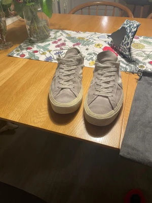 Beige Tom Ford sneakers i mocka - Säljer ett par snygga Tom Ford sneakers i beige mocka med vit detalj på sidan och vit platt sula. Skorna har snörning och rund tå, med Tom Ford-logga bak på hälen. Perfekta för dig som gillar stilrena och exklusiva sneakers.