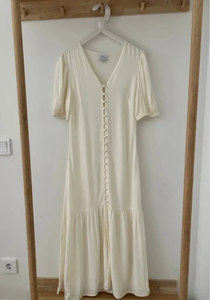  Vit klänning & Other Stories - Vit klänning från & Other Stories Paris Atelier med v-ringning, korta ärmar och klädda knappar framtill. I mycket bra skick 