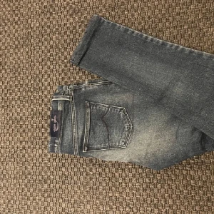 Mörkblå jeans från Jacob Cohën - Snygga mörkblå jeans från Jacob Cohën med en klassisk femficksdesign. Jeansen har en lätt tvättad look och är tillverkade i ett bekvämt denimtyg. Perfekta för en stilren vardagslook. modellen är slim fit. I butik kostar dom 5000 nya. W27. Skriv vid funderingar!😁🤩