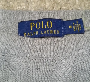 kabelstickad  Ralph Lauren tröja - Säljer en klassisk grå stickad tröja från Polo Ralph Lauren med kabelstickat mönster och broderad logga på bröstet. Tröjan har rund halsringning och långa ärmar. Perfekt för en stilren och tidlös look. Tröjan är i storlek M så passar perfekt om du är runt 180.  Skick 8.5/10. Priset kan diskuteras vid en snabb och smidig affär. Hör av er vid minsta fråga🤗💸