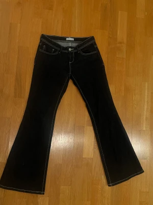 Svarta bootcut jeans med kontrastsömmar - Snygga mörkblåa jeans från Gina tricot med bootcut-ben och vita kontrastsömmar. Klassisk femficksmodell och låg midja. Jeansen har en stilren look och är tillverkade i mjukt denim-material som sitter skönt hela dagen.
