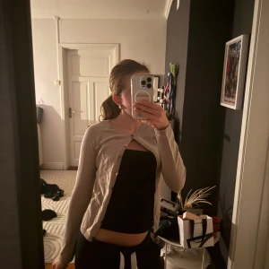 Beige kofta från H&M med knappar - Säljer en beige kofta från H&M i storlek 32-34. Koftan har rund halsringning, långa ärmar och knäppning framtill med små knappar. Tunn och mjuk, perfekt att slänga över ett linne eller t-shirt. 