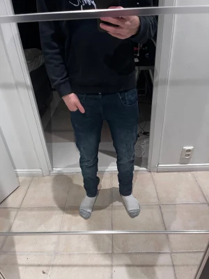 Mörkblå Replay Anbass jeans herr - Säljer ett par mörkblå Replay Anbass jeans med klassisk femficksdesign och snygga slitningar. Jeansen har smal passform och är tillverkade i stretchig bomullsdenim för extra komfort. Perfekta för dig som gillar en modern och stilren look. I storlek 29/32