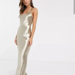 Champagnefärgad balklänning - En fin balklänning i champagne/guld färg. Den är endast använt en gång på balen, den ser helt ny ut det enda är att det är kvar lite klister på innersidan av ryggen då den var för stor för mig vid tillfället(se sista bild). Men detta syns inte eftersom det är på innersidan. Jag är 160cm och den passar perfekt ner till fötterna med klackar. 