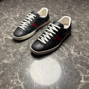 Gucci ace - Säljer ett par otroligt snygga skor från det exklusiva italienska märket Gucci! Skorna är i mycket bra skick, skulle säga ungefär 9/10. Nypris ligger på över 9000kronor men vi säljer våra för endast 1699 och kan gå ner i pris ännu mer vid snabb affär! Skorna är i storlek 42. Skriv gärna ifall det är några funderingar, allt bästa SkoKapet