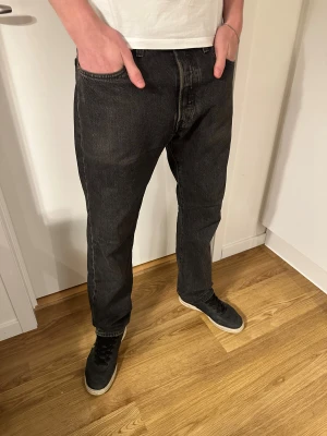 Levi's 501 svarta jeans straight fit - Svarta Levi's 501 jeans med klassisk straight fit! Lite slitningar vid hälarna men annars i mycket bra skick. Ny pris: 1149 kr Säljs för 300 kr