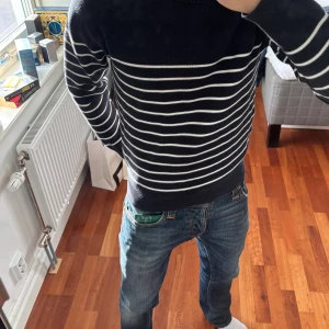 Mörkblå randig tröja från Uniqlo - Snygg mörkblå stickad tröja från Uniqlo i storlek XS. Modellen är 174cm 63kg. Denna är även  unik, vilket gör den skitsnygg. Säljer den för att den är liten på mig. Den är även helt ny. Bara använd ett fåtal gången!