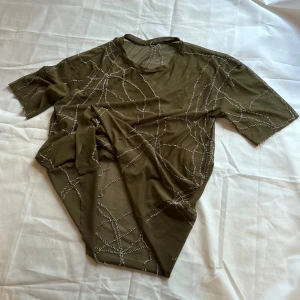 Olivgrön mesh t-shirt med handbroderi  - Passar storlek xs-L. Sitter oversized på storlek S. 
