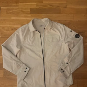 Cp company overshirt - Säljer denna snygga cp company overshirt som är beige. Den är storlek M men kan passa S också beror på hur man vill ha den.