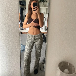 Leopardmönstrade jeans - Säljer ett par snygga low waist / mid waist jeans med leopardmönster i beige och grå toner. Byxorna har raka ben med en loose fit.  Använda ett fåtal gånger, perfekt längd för mig som är 172