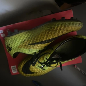 Nike Hypervenom elite - Nike Hypervenom fotbollsskor i en cool gul färg med svarta detaljer och snörning. Skorna har en strukturerad syntetisk ovandel för bättre bollkontroll och en platt sula med dobbar för spel på gräs. Swoosh-loggan syns tydligt på sidan och tån. Passar mig med 42 i mercs.  i väldigt bra skick sällsynt 
