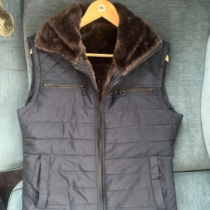 dunväst med pälsfoder - En skit snygg och eftertraktad väst med full päls lining. Strl 48 men passar som S/M och okänd märke. 