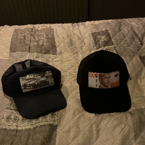 Svarta kepsar från Emilio Pendenza - Två velvet kepsar från Emilio Pendenza. Ena kepsen har ett tryck med en klassisk sportbil i svartvitt, den andra har ett tryck av en svensk 1000-kronorssedel. Båda har mesh på sidorna och justerbar baksida. Perfekt för dig som vill sticka ut med coola detaljer.