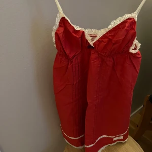 Odd Molly tunika  -  Röd söt tunnika från Odd Molly  med tunna axelband och vacker vit spets längs kanterna. Tunnikan har broderade blommor nertill och dekorativa veck framtill. Storlek 2 ca 36-38. 100% . Knappt använd . Finns i Liljeholmen, kan skickas .