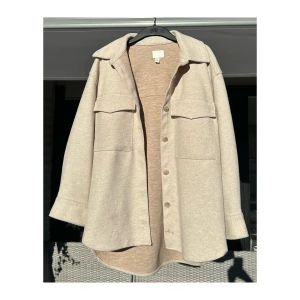 Beige Oversized Wool-Blend Shacket - H&M - Stylish beige oversized shacket (shirt jacket) from H&M🧸🌟  - shoulder width 52cm - length 74cm - material: polyester, viscous, elastan - Perfect for layering during autumn and spring. - Front button closure - large chest pockets - relaxed fit for a casual yet chic look💅🏼✨ - Light pilling from wear, but still looks great overall