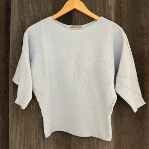 Ljusblå trekvartsärmad topp - Ljusblå trekvartsärmad topp, går ihop smalare i midjan