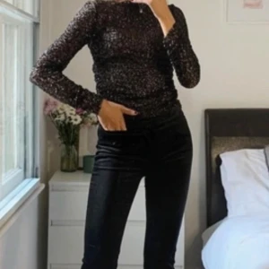 Glittrig svart långärmad topp Zara - Säljer en svart långärmad topp från Zara med glittrigt material. Toppen har en rund halsringning och är figurnära i modellen. Perfekt för att sticka ut med sin skimrande look och passar till många olika outfits.