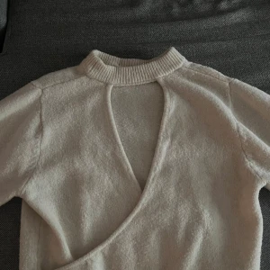 Beige stickad tröja från MNG - Stickad tröja från mango med öppen rygg, använd fåtal gånger och i mycket bra skick.