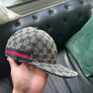 Gucci Keps - 🧢 GG Keps – Ny & Fräsch 🧢 🔥 Helt ny Gucci keps i klassisk Röd/mörkblå design med Gucci-mönster. ✨ Passar perfekt till alla outfits – vardag som fest. 📦 Leveranstid: 1–3 dagar, 📍 Endast kepsen ingår, 💎 Ge din stil en lyxig touch!