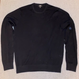 Svart stickad tröja från Uniqlo - En klassisk svart stickad tröja från Uniqlo med rund halsringning och långa ärmar. Perfekt för lager-på-lager och enkel att matcha med allt. Mjuk och skön känsla, passar dig som gillar stilren och enkel design.