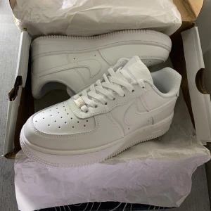 Vita air force 1 - Säljer mina fina Air Force som tyvärr blivit liggande. Helt nya och oanvända 🤍 Klassiska, fräscha och passar till allt – både till jeans, klänning eller mjukisset! Storlek 38, normal i passformen. skickas snabbt & tryggt. Perfekta för dig som älskar clean och stilren look! 