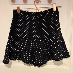 Svart prickig volangkjol - Svart prickig kjol med volang från Zara. Storlek XS-S. Använt fåtal gånger.