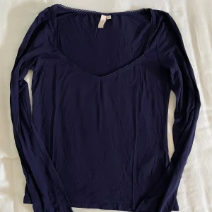 U-ringad marinblå långärmad tröja - En marinblå u-ringad långärmad tröja från Nelly i storlek M men passar även S. Aldrig använt.