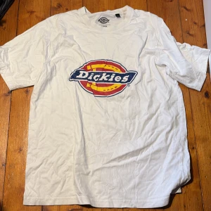 Vit Dickies t-shirt med logga - Vit t-shirt från Dickies med stor färgglad logga på bröstet i blått, rött och gult. Klassisk passform med rund hals och korta ärmar. 