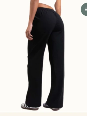 Svarta linneinspirerade byxor med loose fit - Säljer ett par svarta byxor med snörning i midjan och raka, lösa ben. Sköna och enkla att dra på sig, perfekta för chill dagar. Materialet känns mjukt och luftigt, och passformen är relaxed med en klassisk look.