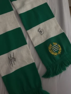 Hammarby halsduk signerad av Nahir Beshara - Hej! Jag säljer en Hammarby halsduk som är signerad av Nahir Beshara som är nuvarande kapten för Hammarby (video bevis finns när han signerar!) Halsduken är allmänt i sig i bra skick. Priset är ej hugget i sten!!!!! Vid frågor tveka inte att höra av dig!